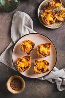 Homemade caramelized onion savory pies on a plate on the table top and vertical view photo