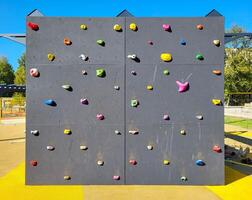 Climbing wall on the playground on a clear sunny day outside. photo