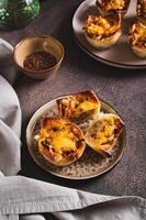 Homemade caramelized onion savory pies on a plate on the table vertical view photo