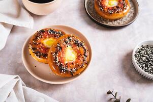 Egg with tomato and sesame seeds baked in bagels on a plate on the table photo