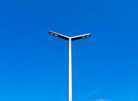 On the background of the blue sky, a pillar with rectangular lamps LED street lights. photo