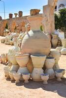 Array of traditional pottery. A large pile of gracefully shaped jugs, pots and bowls in earthy tones and rustic textures. A trip to Guellala, pottery village in Tunisia photo