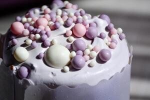 close up of a beautifully iced cake adorned with pastel-colored sprinkles. Smooth creamy icing with artistic arrangement of candy beads, creating a whimsical and inviting appearance. Eastern pastry photo