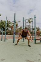 An athlete is doing power training exercises with an elastic band photo