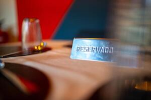 Metal reservado sign placed on a set restaurant table, indicating a reservation, with glasses, plates, and cutlery arranged, creating an elegant and inviting ambiance photo