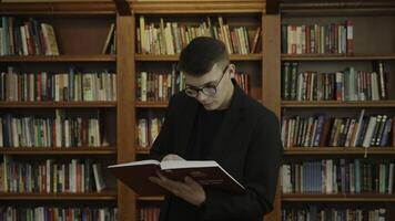 A Young Scholar Immersed in Reading a Book Inside a Quiet Library Space for Learning. Media photo
