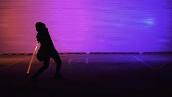 A Dynamic Silhouette illuminated by Neon Lights, wielding a Sword in an engaging scene. Media photo
