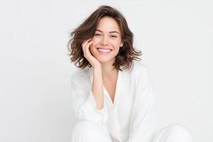 Smiling woman in white attire with natural beauty and joyful expression sitting against a light background showcasing happiness and confidence concept photo