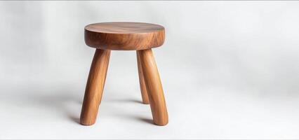Simple and elegant, small wooden stool on white background, showcasing minimalist design and craftsmanship photo