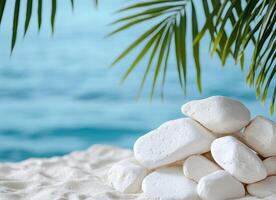 Soft sandy beach with white stones, palm leaf silhouettes creating serene frame around turquoise waters and misty shoreline photo