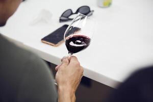 Portrait from the back of professional sommelier looking red wine and analysis color, close up shot. photo