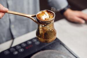 Boiling Traditional Turkish Jezve on Modern Stove Capturing the Moment of Overflow photo