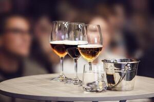 Three Different Sort of Beer in Glasses - Lager, Unfiltered and Stout on table near Spittoon, Close-up photo