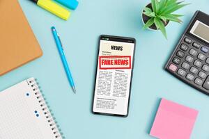News on smartphone and notebook on blue background photo