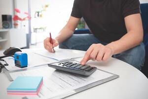 A man is using a calculator to do some math photo