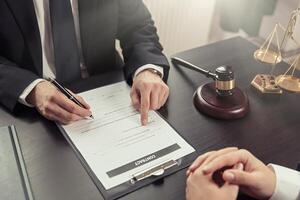 A man in a suit is signing a document with a woman photo