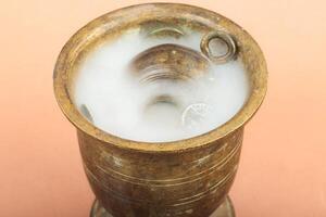 Old bronze mortar with ancient coins and mist rising from inside. photo
