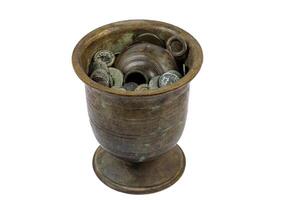 Ancient bronze vessel filled with Roman coins on white background photo