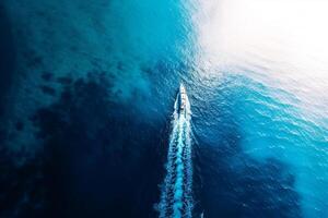 A boat is in the water with a wake behind it photo