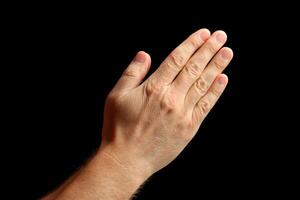 Hand raised in a gesture of greeting or acknowledgment against a dark background photo