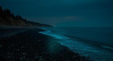 Nighttime beach landscape with calm waves and distant shorelines under a dark sky photo