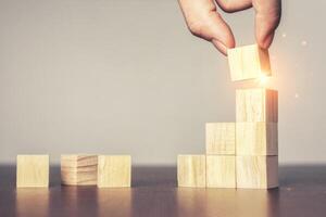 Hand arranging wood block stacking as step stair on table.New normal Business development Decide and choose, Business concept for growth success process,Vintage tone.Copy space photo