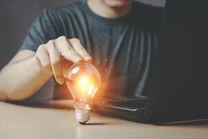Men working at home with light bulbs. New ideas. Inspiring and different thinking with new innovations and technologies, saving electricity and the environment. Small home business ideas. photo
