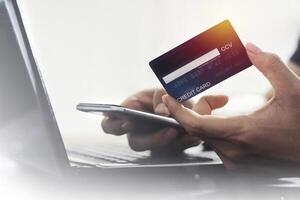 User Filling information on the back of credit card. With mobile phone for online shopping E-payment technology, or mobile phone financial application concept, copy space, credit card mockup photo