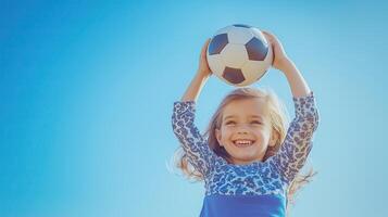A little girl holding up a soccer ball photo