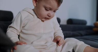 A baby plays with toys on a couch, exploring joy and creativity video