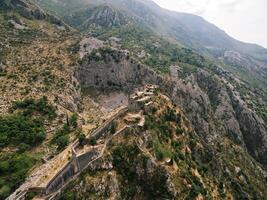 Walls of St. John fortress on a rocky mountain in Kotor. Montenegro. Drone photo