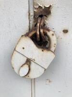 Antique padlock, reliable security, covered in rust photo