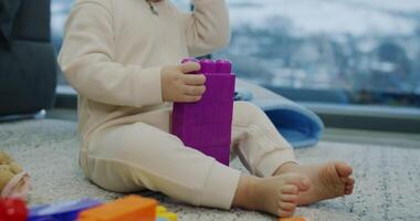 A baby joyfully plays with colorful blocks, highlighting childhoods innocence video
