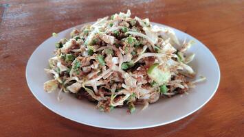 Gado-gado is a traditional Indonesian salad consisting of vegetables, potatoes, tempeh, tofu, carrots, tomatoes, lettuce, eggs, rice cake and peanut sauce. photo