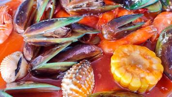 clams, shrimp, green mussels, corn, squid, and crab. Seafood with spicy sauce photo