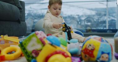 A boy joyfully plays with colorful toys in a cozy living room video