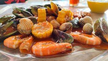 cockles, shrimps, green mussels, corn, squid and crabs. Close up footage of various seafood with spicy sauce photo