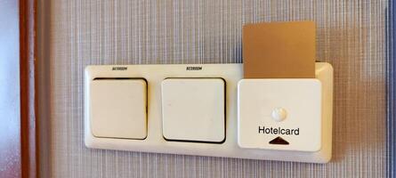 inserting a card key into a switch in a modern hotel room during the day. photo