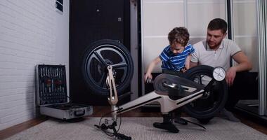 A man and boy bond while fixing a bicycle, highlighting teamwork video