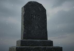 Gravestone with Rip Inscription Against a Cloudy Sky During Snowfall photo