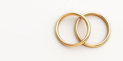 Two interlocked gold wedding rings on a minimalist white background photo