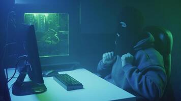 cybercriminal hacker puts on a mask and types on a keyboard video