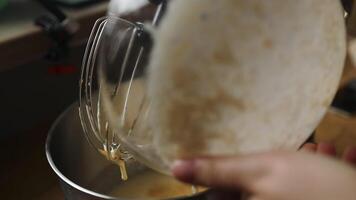 Pouring batter from bowl into mixer for baking recipe video