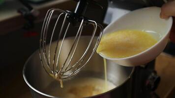 Pouring melted butter and eggs into mixer for baking video