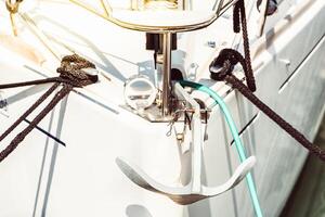 Sailboat anchor in sunlight showing nautical details and rope, background photo