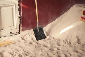A Shovel is Resting on a Soft Sandy Floor located within an Indoor Environment Space photo