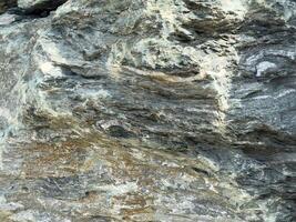 Close-up of textured rock surface with natural patterns and layers photo