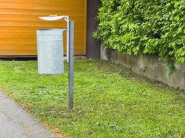 Empty outdoor trash can with canopy lid in urban park setting photo