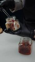 Adding sun-dried tomatoes to jar with smoked fish video