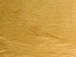 Textured yellow paper surface with natural wrinkles and folds photo